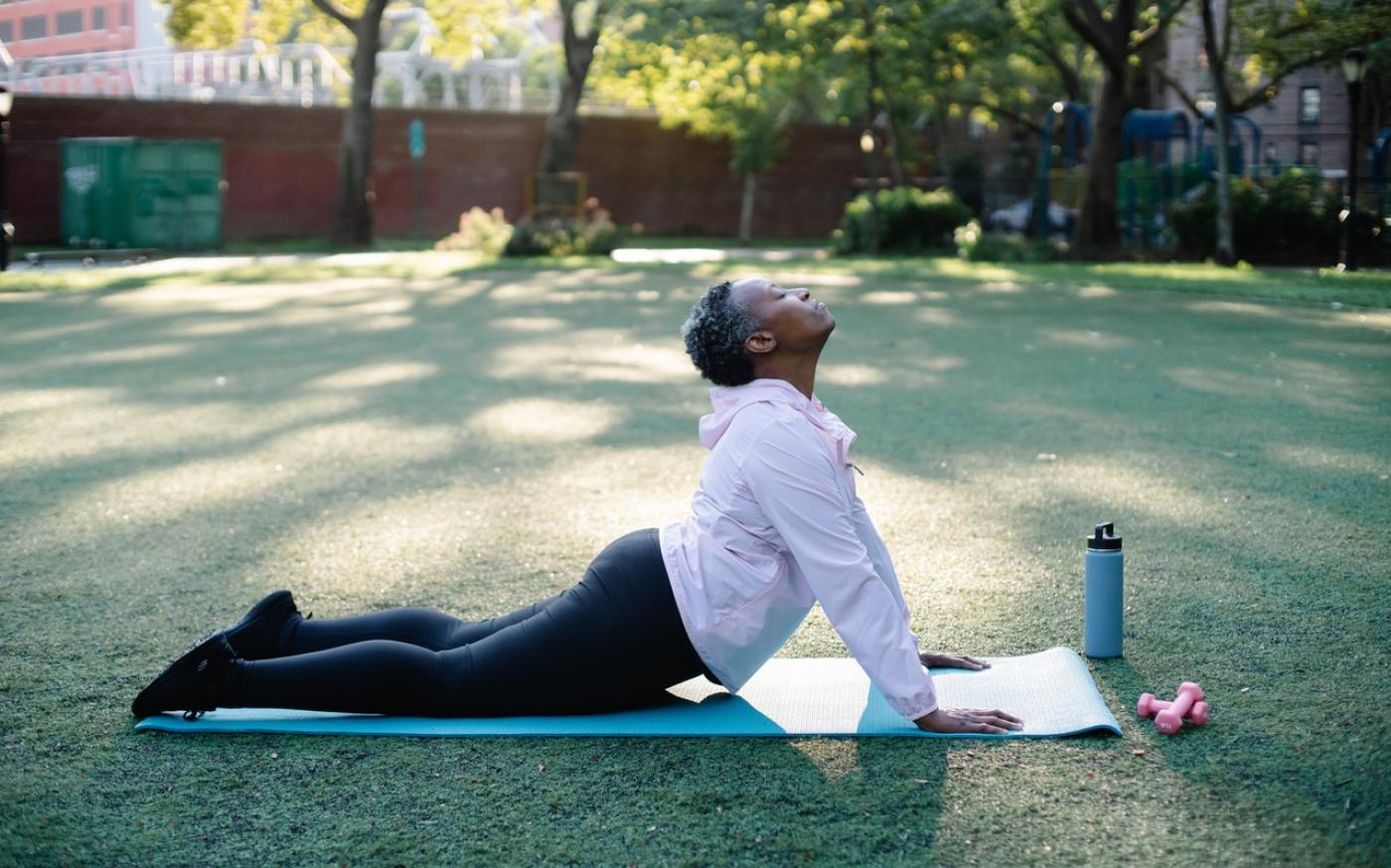 Elderly woman doing yoga in a park